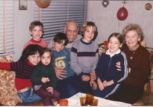 Mario J. (Grandpa) con Maxi y Alex en sus rodillas junto a Inés y otros nietos